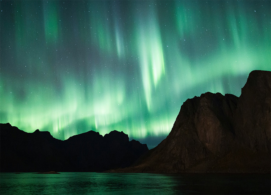 Aurora over Nordic mountain lake
