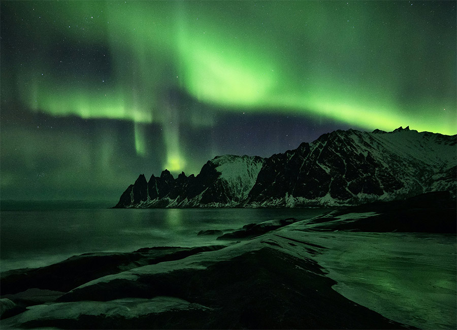 Aurora over rugged Nordic coastline
